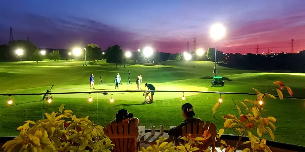 Friends sit on the Badlands patio and watch a group of golfers on the 9th green.